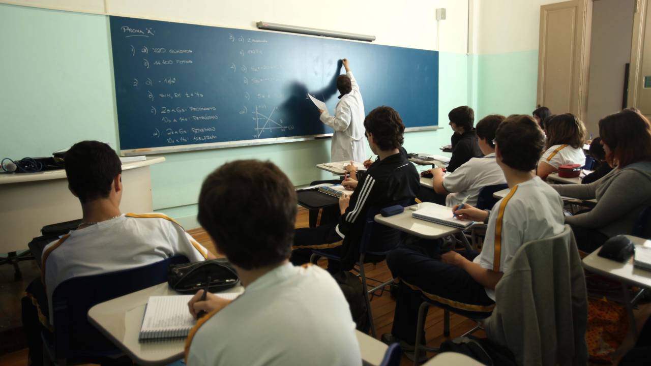 Alunos aprendem em sala de aula de escola particular