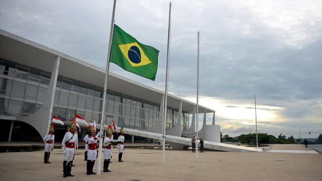 Soldados da guarda presidencial em Brasília levantam bandeira em homenagem as vítimas de um incêndio boate de Santa Maria