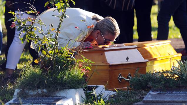 Lívia Oliveira, mãe de Heitor, beija seu caixão durante funeral, em cemitério de Santa Maria