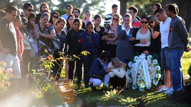 Parentes e amigos de Heitor de Oliveira se reunem em torno de seu caixão durante o funeral no cemitério de Santa Rita em Santa Maria
