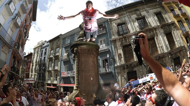 Jovem salta da fonte de Navarra, durante o tradicional Festival de São Fermino, na cidade de Pamplona, ao noroeste da Espanha. Todos os anos milhares de pessoas de todo o mundo participam das festividades em homenagem a São Firmino, o santo padroeiro da cidade