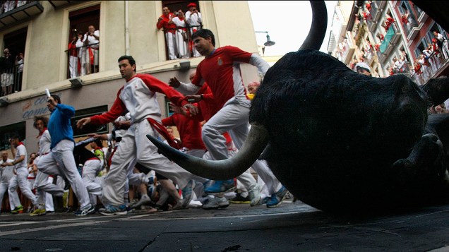 Foliões são fotogrados durante a segunda corrida de touros do Festival de São Fermino, na cidade histórica de Pamplona, na Espanha. A tradicional corrida faz parte das atividades que integram os nove dias de festa