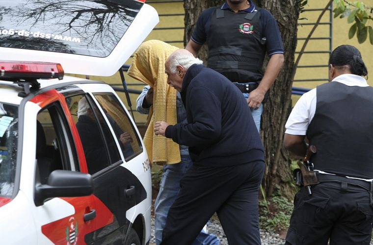O médico Roger Abdelmassih e outro preso, que esconde o rosto, no IML Central de São Paulo, na terça-feira, pouco antes de serem transferidos para o presídio de Tremembé.