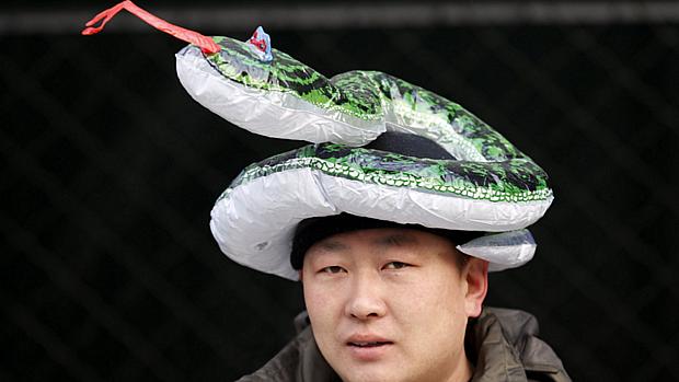 Dono de loja tenta atrair fregueses com chapéu em homenagem ao Ano da Serpente