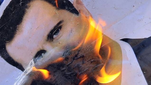 Retrato do presidente sírio, Bashar al-Assad queimando durante confrontos entre rebeldes e as tropas sírias no distrito de Salaheddin norte da cidade de Aleppo