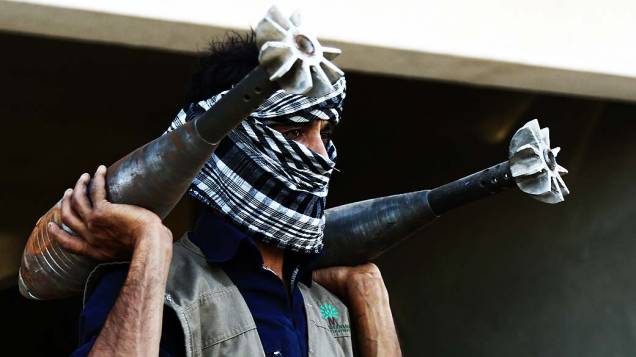 Rebelde sírio carrega morteiros caseiros na cidade de Raqqa, nesta quarta-feira (04)