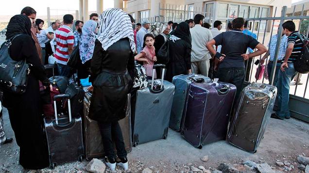 Refugiados sírios fazem fila perto da fronteira com a Turquia para tentar deixar o país. A ONU divulgou na terça-feira (3) que o número de refugiados sírios chegou a 2 milhões
