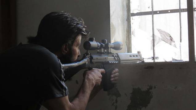 Franco-atirador do Exército Livre da Síria se posiciona para monitorar movimentos de soldados do governo