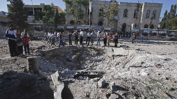 Civis observam destruição causada por bombardeio da força aérea síria na cidade de Azaz