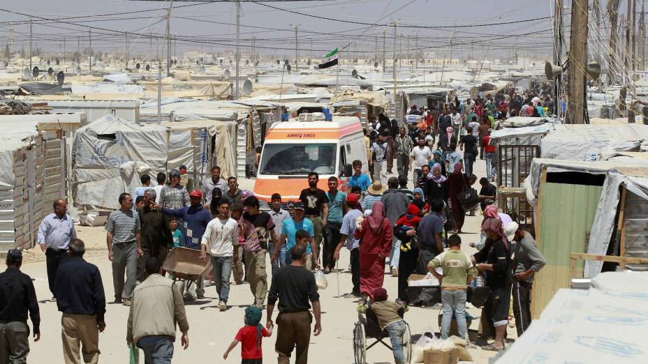 Sírios caminham no campo de refugiados Al Zaatri, na cidade de Mafraq, na Jordânia