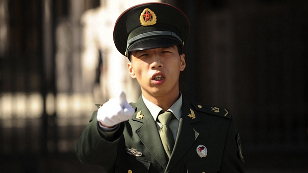 Soldado chinês proíbe fotos diante do hotel onde se hospedam os participantes do encontro