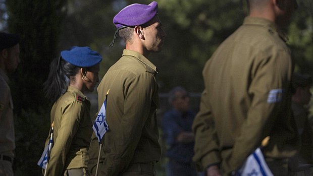 Soldados israelenses seguram a bandeira nacional