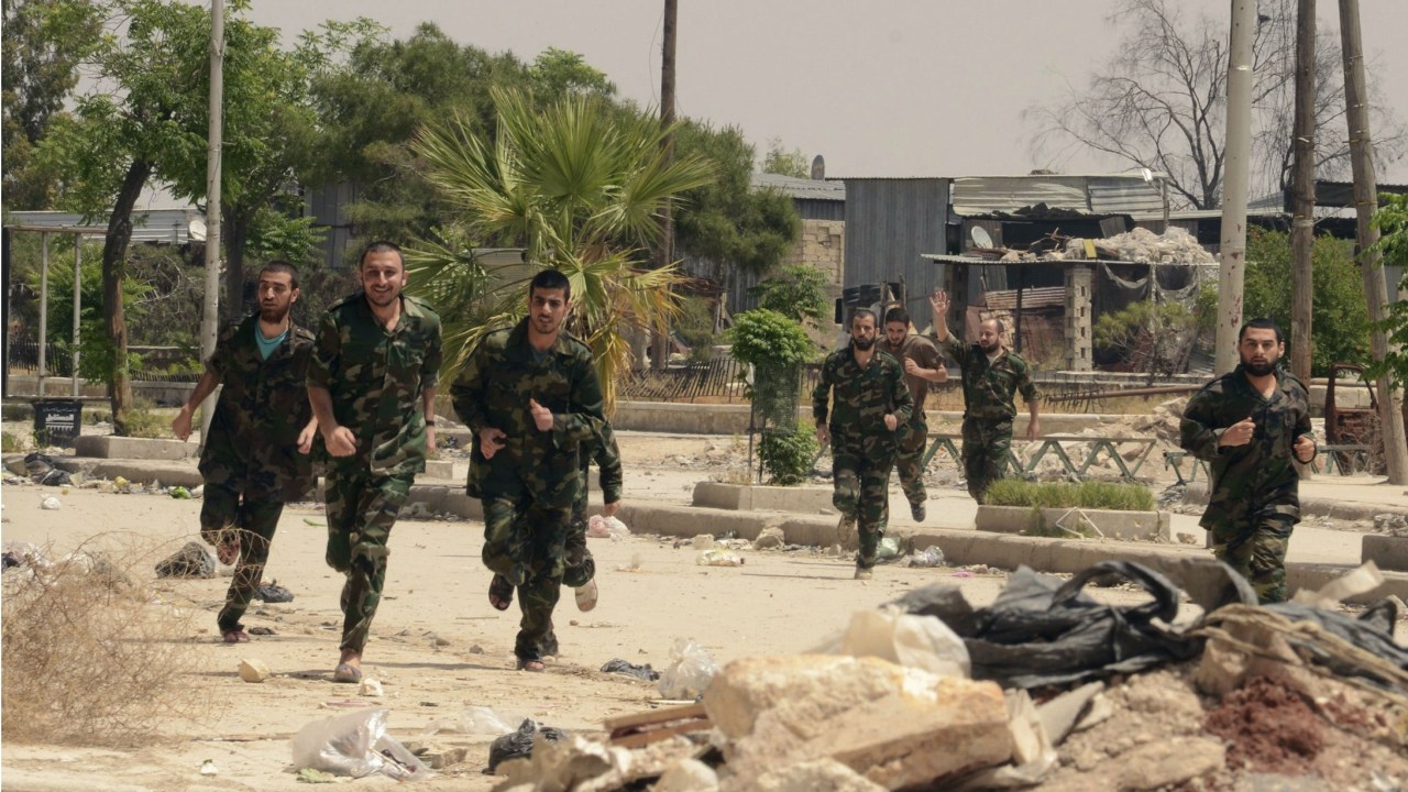 Soldados leais a Bashar Assad correm para longe do cativeiro após rebeldes sírios de Aleppo concordarem com os termos de um acordo mediado pela ONU