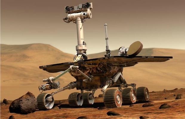 Concepção artística do veículo Spirit na superfície de Marte. Dois idênticos, Opportunity e Spirit, foram construídos e lançados em 2003 e chegando em 2004 ao solo marciano. Os vaículos possuem a capacidade de funcionar como um geólogo robô
