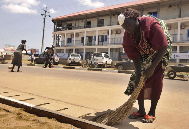 Em Juba, trabalhadora limpa rua para as comemorações do primeiro aniversário do Sudão do Sul