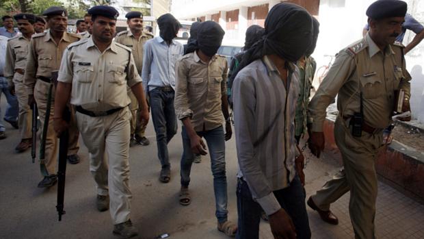 Suspeitos são escoltados por policiais para delegacia na Índia. Eles teriam participado do estupro coletivo de uma turista suíça
