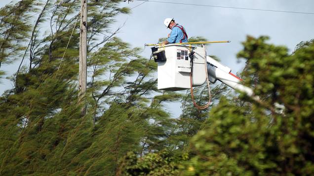 Funcionário da companhia de energia tenta religar os cabos que foram danificados após a passagem da tempestade tropical Isaac, em Key West, cidade da Flória, nos EUA