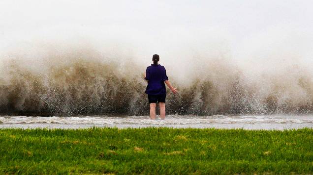 Mulher observa as ondas provocadas pelo vento à beira do lago Pontchartrain em Nova Orleans, com a aproximação do furacão Isaac à cidade