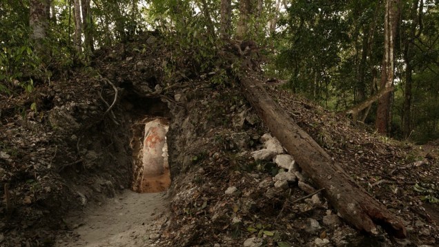 <p>A figura de um homem, possivelmente um escriba que viveu na casa construída pelos maias, é iluminada na porta que dá acesso à residência, no nordeste da Guatemala. É a primeira casa maia encontrada com representações artísticas nas paredes.</p>