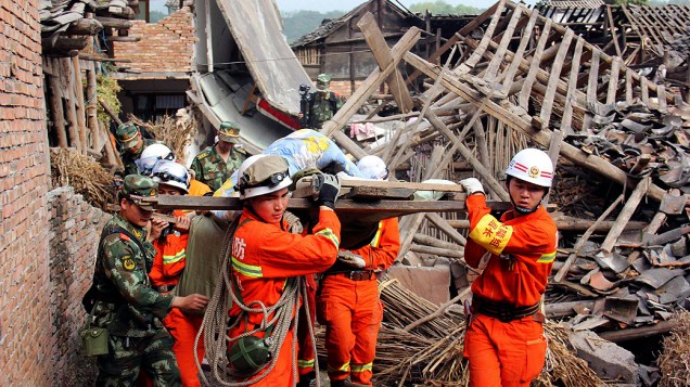 Equipes resgatam idosa na província chinesa de Sichuan, neste domingo (21), após terremoto que deixou mais de 150 mortos
