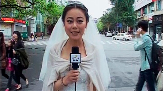 A jornalista Chen Ying grava uma reportagem sobre a tragédia na China usando seu vestido de noiva após terremoto que atingiu a província de Sichuan. A jornalista e noiva fez a reportagem e depois seguiu para o próprio casamento
