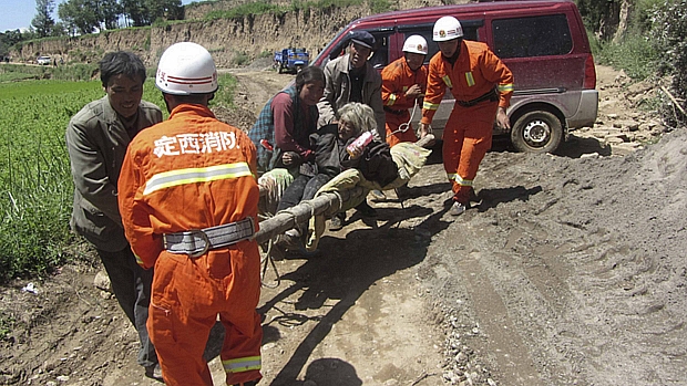 Mulher ferida é socorrida na província de Gansu após tremor de 6,6 graus