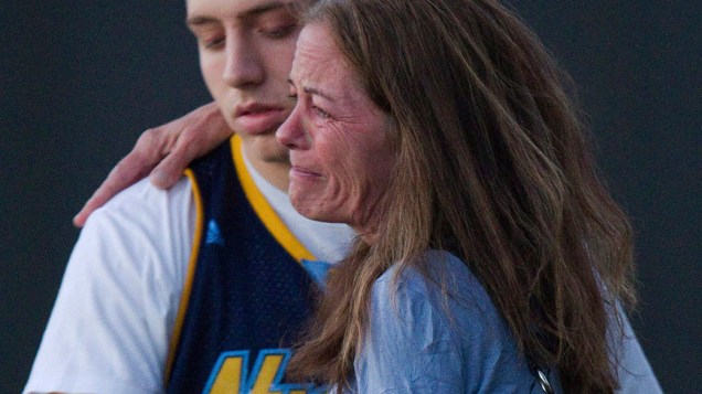Jacob Stevens, 18, abraça sua mãe Tammi Stevens depois de ser interrogado pela polícia após o ataque de um atirador em um cinema, de Denver, Colorado