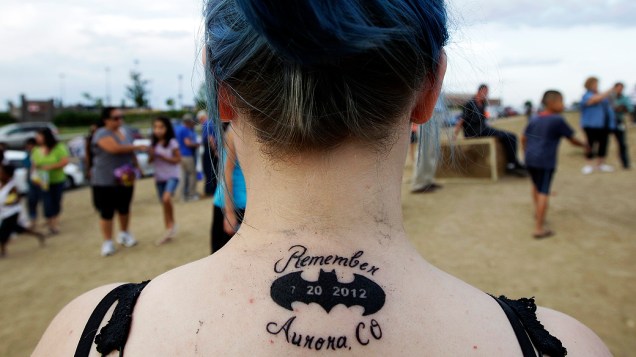 Americana mostra a tatuagem que fez em homenagem às vítimas do tiroteio de sexta-feira em Aurora, no Colorado, durante a estreia do novo filme do Batman