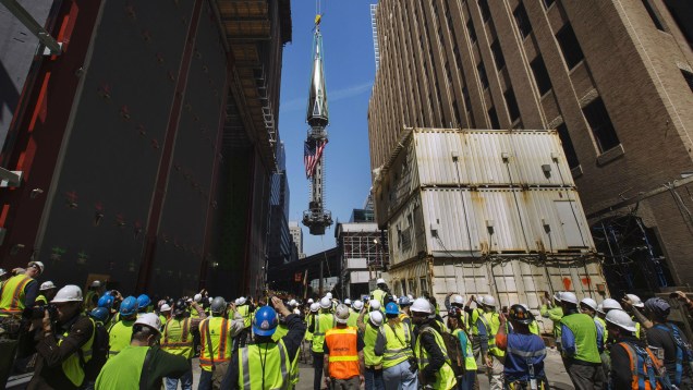 Trabalhadores observam a instalação da antena da nova torre onde ficava o complexo do World Trade Center.