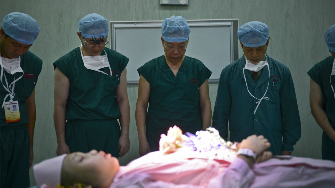 Médicos chineses rezam antes de operação de retirada de órgãos para transplante
