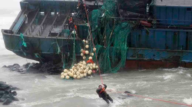 Pescadores deixam a embarcação que naufragou em Seogwipo, na ilha de Jeju (Coreia do Sul), após a passagem do tufão