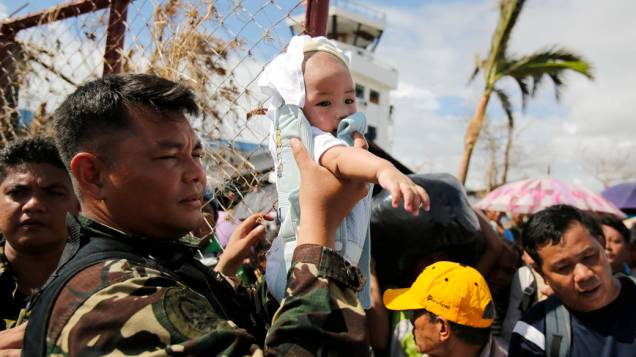 Em Tacloban, soldado segura bebê antes de embarcar para a capital Manila