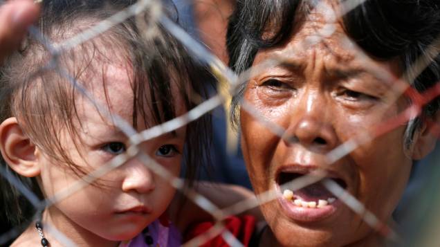 No aeroporto de Tacloban, mulher espera para ser levada de helicóptero para Manila
