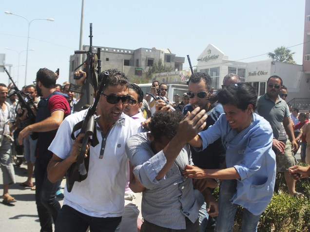 Ofiiciais da polícia escoltam homem suspeito de estar envolvido no atentado a um hotel em Sousse, na Tunísia
