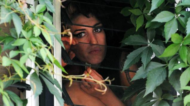 Amy Winehouse na janela de sua casa em Londres em 2008