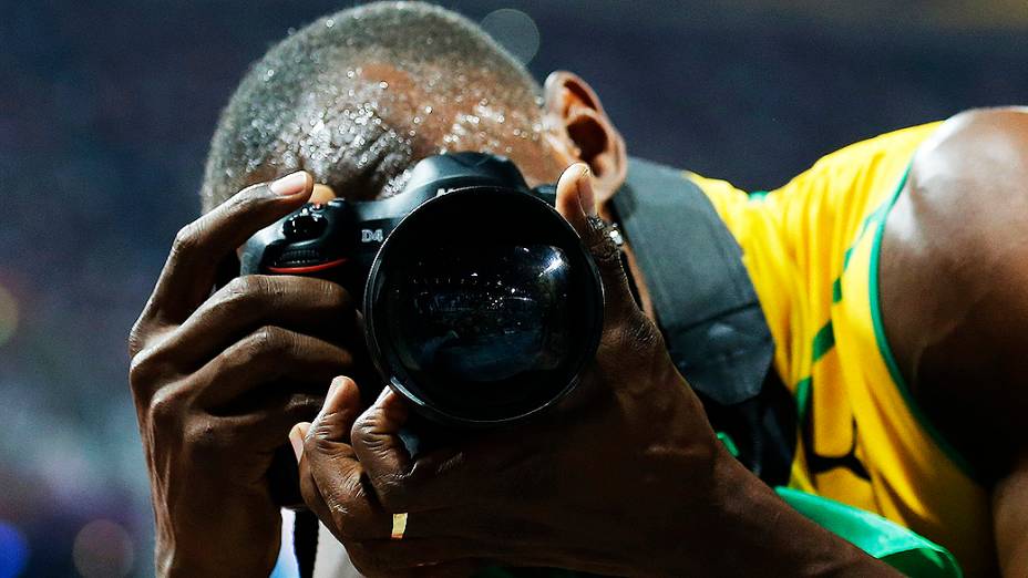 Usain Bolt tira foto com câmera de fotógrafo após a conquista dos 200 m rasos em Londres