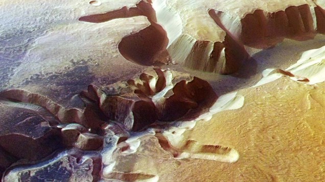 <p>Foto registrada pela missão da agência européia Mars Express, em setembro de 2005. A parte escura mostra uma rede de vales que se parecem com as redes de drenagem da Terra. A ciência ainda não descobriu se esses vales originaram-se à partir de chuvas, lençóis subterrâneos ou derramamentos de magma na superfície.</p>