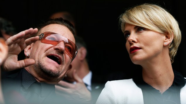 A atriz sul-africana Charlize Theron e o cantor Bono aguardam o início da cerimônia no FNB Stadium, nesta terça-feira (10)