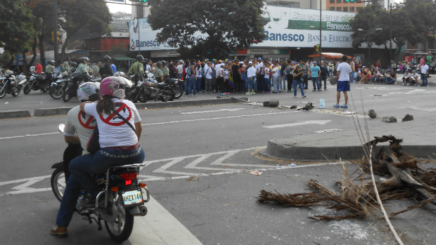Observados pela polícia, manifestantes bloqueiam rua de Chacao
