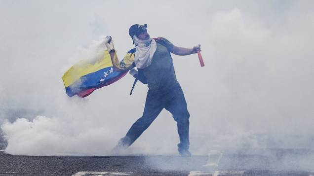 Homem enfrenta a Guarda Nacional Bolivariana durante protesto na Venezuela, nesta quinta-feira (27)