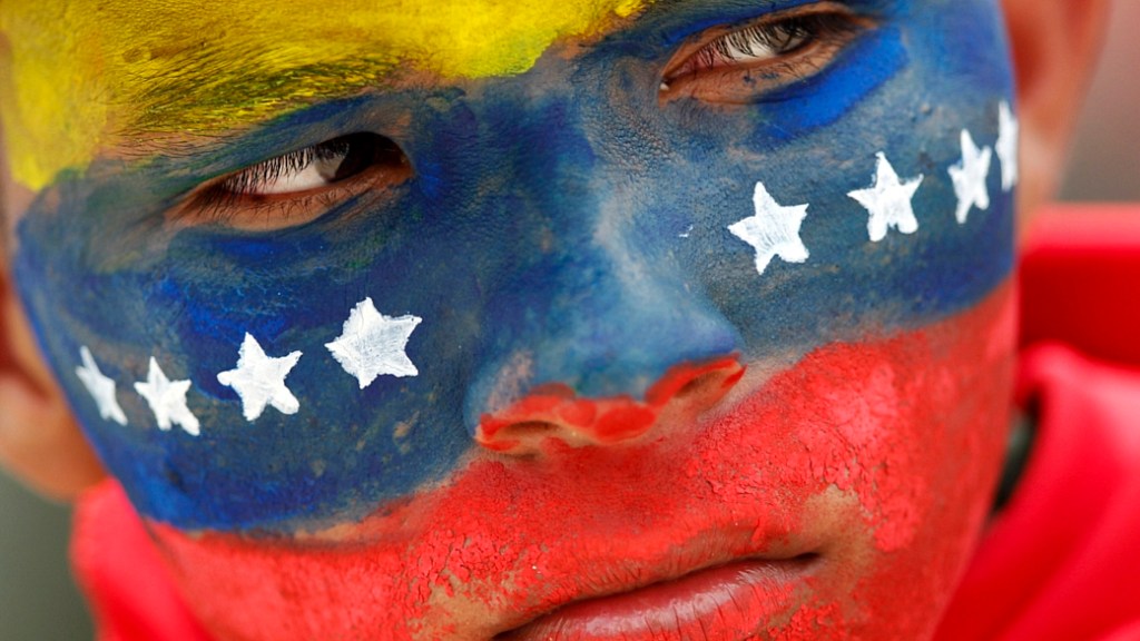 Soldado venezuelano pinta o rosto para participar de ato chavista