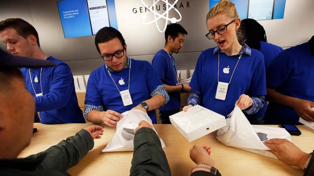 Funcionários atendem clientes durante compras do novo iPad Air dentro Apple Store na Quinta Avenida, em Nova York