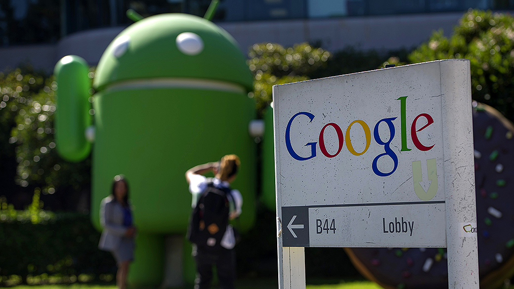 Pedestres tiram fotos em frente ao escritório do Google, em Mountain View, Califórnia
