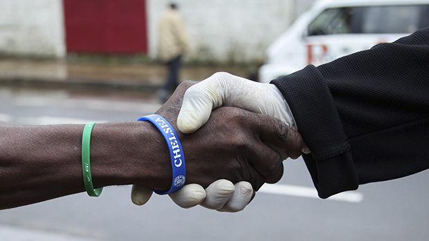 Um homem usa luvas de plástico para evitar contaminação pelo vírus Ebola, na cidade de Monrovia, na Libéria  