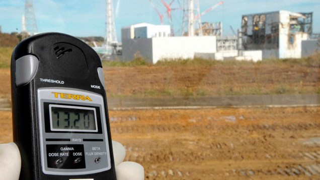 Jornalista mostra medidor com o nível de radioatividade nos prédios da usina nuclear de Fukushima, no Japão