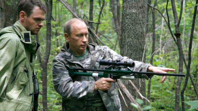 Vladimir Putin com uma arma de tranquilizantes durante visita a Academia de Ciências Ussuri, na Rússia, em agosto de 2008