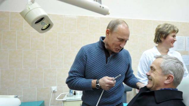 Vladimir Putin brinca com Yevgeny Savchenko, governador de Belgorod, em uma sala de odontologia em novembro de 2011