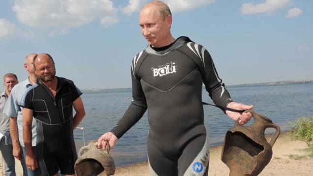 Vladimir Putin carrega duas ânforas que encontrou enquanto mergulhava na Península de Taman na Rússia em agosto de 2011