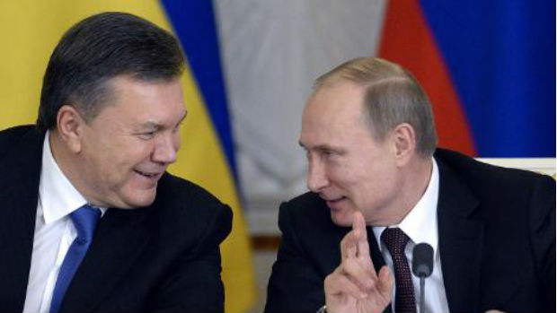 Putin (d) e Yanukovych conversam no Kremlin durante a assinatura do acordo
