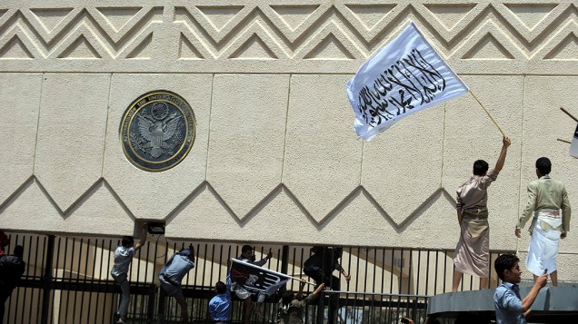 Manifestantes seguram uma bandeira com os dizeres "O único Deus é Alá e seu profeta é Maomé" durante protesto na embaixada americana em Sana, no Iêmen